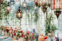a super colorful bridal shower tablescape with spray painted dried blooms and Moroccan lanterns, bold blooms, colorful candles and pink napkins