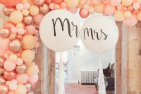 a wedding entrance styled with pink, pearly and blush balloons and white balloons with tassels is a very cool idea