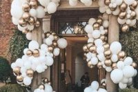 an entrance in a wedding venue all covered with white and gold balloons looks gogeous, statement-like and no worse than if it was covered with blooms