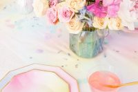 an iridescent wedding table setting with bold chargers, plates and blooms, with an colorful iridescent tablecloth