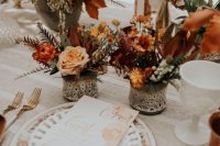 lovely and bright fall boho wedding centerpiece of blush, rust and orange blooms, greenery and colored foliage is amazing