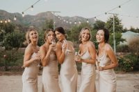 neutral silk slip midi bridesmaid dresses are chic, simple and will never go out of style and a white bridal party is on trend