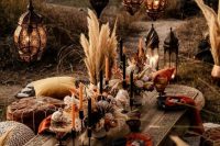 pretty fall boho wedding centerpiece of pampas grass, king proteas, wheat and dried blooms, black and orange candles is gorgeous