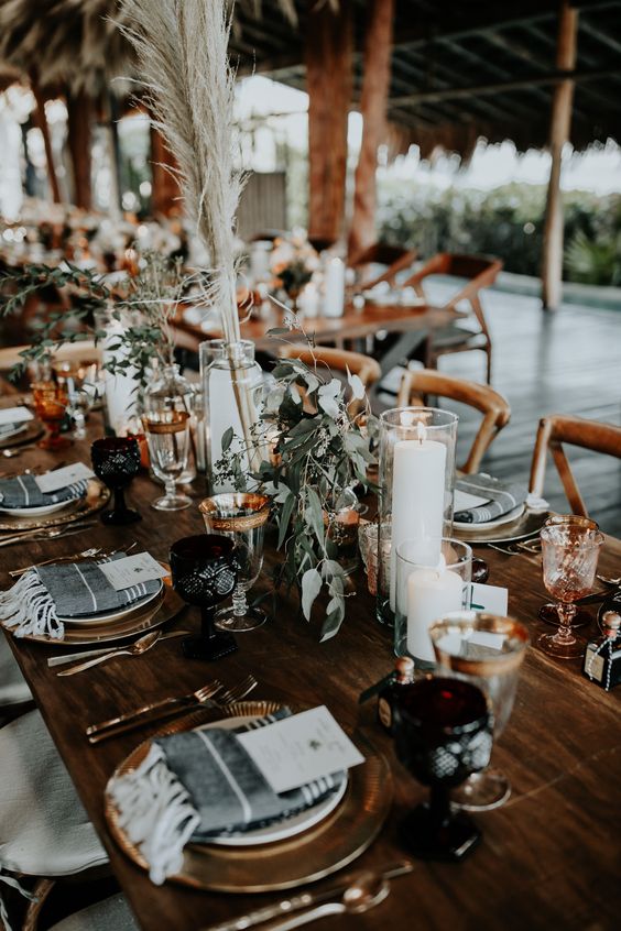 simple boho fall table decor with pampas grass, greenery and some white blooms and candles is a very chic and easy to recreate idea