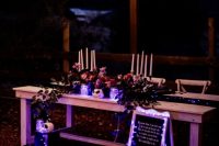 07 a beautiful Tim Burton wedding reception with pink and dark blooms, greenery, purple lights, candles and artworks is wow