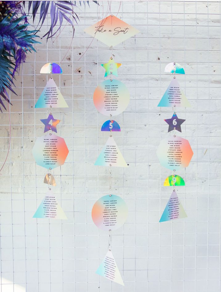 a display of iridescent wedding escort cards shaped in a geometric way is a very fun and cool idea