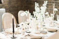 12 a beautiful and sophisticated neutral winter wedding tablescape with warm-colored linens and plates, white blooms, pink and black candles