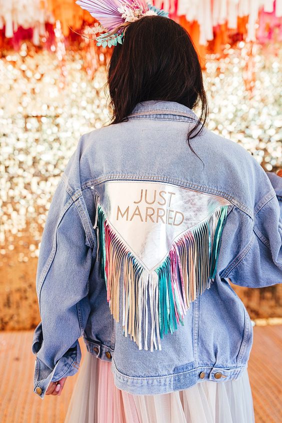 an oversized blue denim jacket with an iridescent back detail and long iridescent fringe for a boho feel