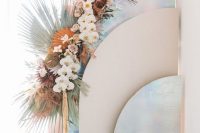 19 an iridescent wedding backdrop with rounded holographic and blush screens and iridescent wedding florals and fronds