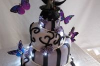22 a lilac and black wedding cake with patterns, Jack and Sally cake toppers, a black crescent moon and lights is stunning