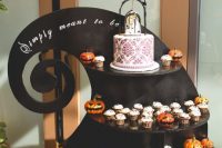 23 a lovely sweet cake stand in black, with cupcakes and a cake, pumpkins inspired by Nightmare Before Christmas