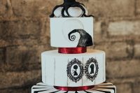 25 a Nightmare Before Christmas wedding cake in black and white, with stripes, with painted art amd a tree on top