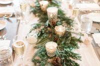 32 a winter wedding table runner of evergreens, pinecones and shiny candleholders with candles is a lovely idea for any type of winter wedding