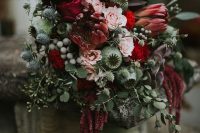 a Halloween wedding bouquet of pink and deep red blooms, thistles, seed pods, greenery, berries and cascading touches is amazing