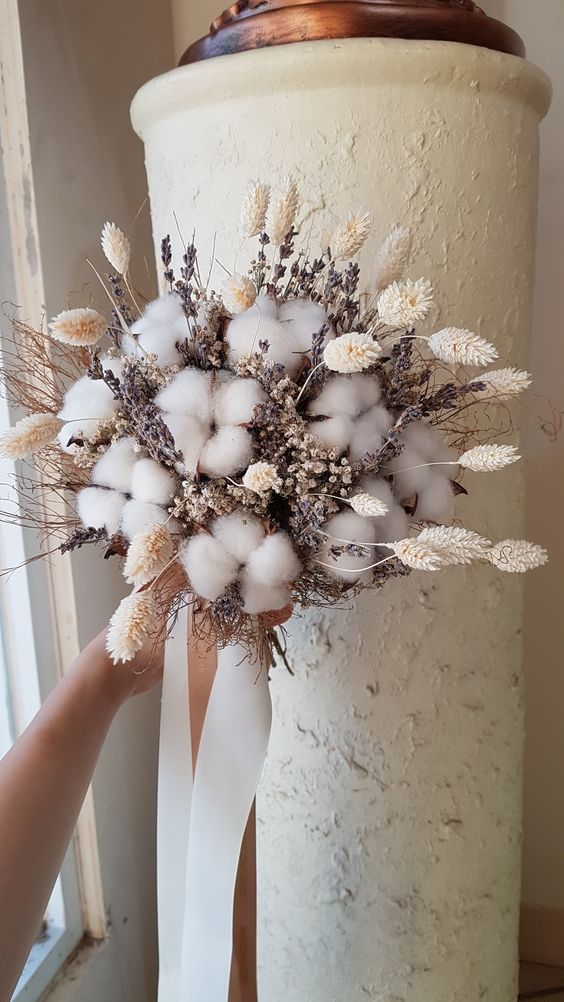 a beautiful dried flower wedding bouquet of cotton, bunny tails, lavender and waxflower plus ribbons is a very cool and fresh idea