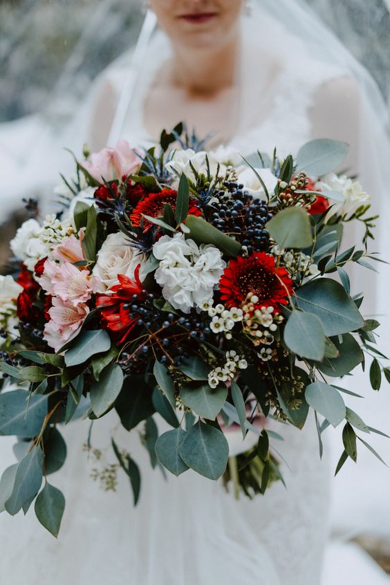 a bold wedding bouquet with white, pink and deep red blooms, waxflowers, berries and greenery for a colorful summer or fall wedding