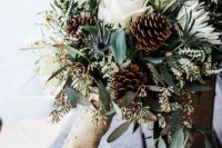 a casual and rustic winter wedding bouquet of white blooms, pinecones, eucalyptus, burlap is a lovely idea for a rustic wedding