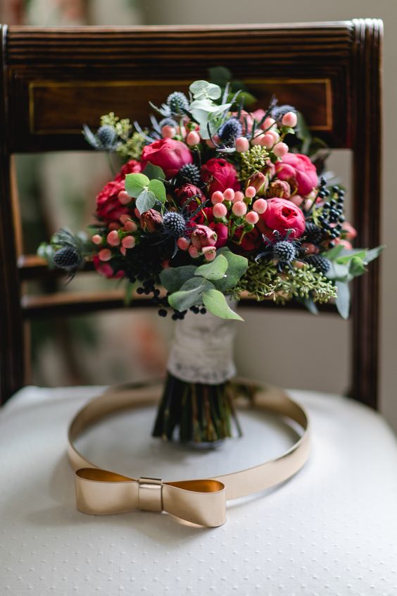 a colorful wedding bouquet of pink blooms, berries, thistles and greenery is a lovely idea for a summer or fall wedding