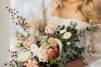 a cool pastel wedding bouquet of white, blush and pink blooms, greenery, berries and thistles for more texture for a fall bride