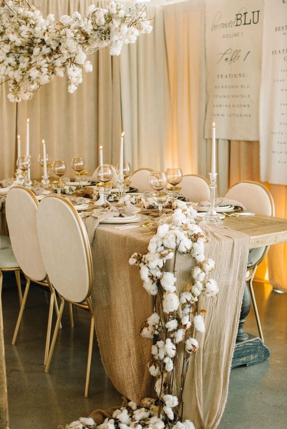 a cotton table runner paired up with a matching overhead installation is a lovely idea, and tall and thin candles add charm
