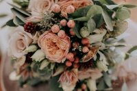 a delicate pastel wedding bouquet of pink and blush blooms, greenery and various berries will work for a summer wedding