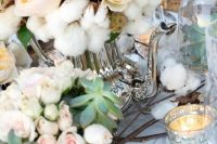 a delicate wedding centerpiece made of blush peony roses and cotton plus succulents and candles is a beautiful idea for a southern wedding
