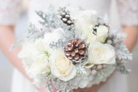 a dreamy neutral wedding bouquet of white blooms, snowy pinecones, berries is a lovely idea for a neutral winter wedding
