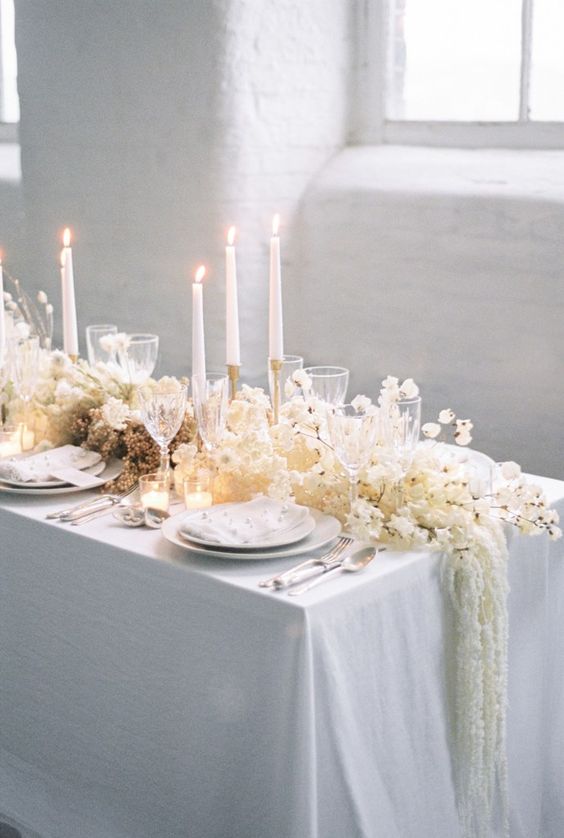 a dreamy wedding table runner with lots of white blooms, cascading touches, lunaria and other dried elements is a gorgeous idea for an ethereal spring wedding