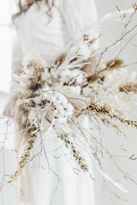 a gorgeous long stem wedding bouquet that includes a lot of cotton, dried blooms, grasses and branches is a gorgeous idea for a boho bride