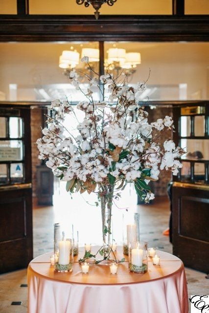 a gorgeous tall wedding centerpiece of magnolia leaves and a cotton is a very lovely idea for a southern wedding, it looks very statement-like