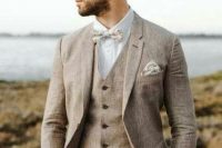 a greige three-piece groom suit with a neutral floral bow tie, a handkerchief are amazing for a cool summer groom’s look