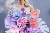 a jaw-dropping iridescent wedding bouquet with colorful fronds, blooms and leaves, in purple, pink and blue is amazing
