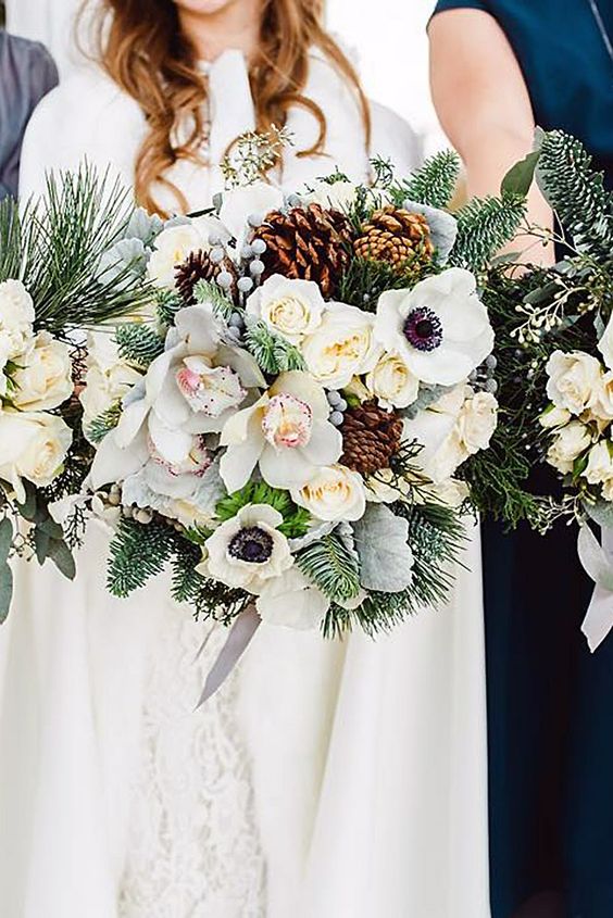 a large winter wedding bouquet of white blooms, evergreens, berries, pinecones and some grey ribbons is a lovely idea