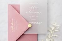 a minimalist wedding invitation suite with a pink envelope and a yellow button and a semi sheer invite with white calligraphy
