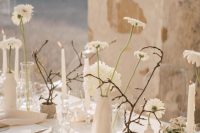 a refined minimalist wedding table setting done in warm neutrals, with blooms, willow, elegant linens and chargers is cool