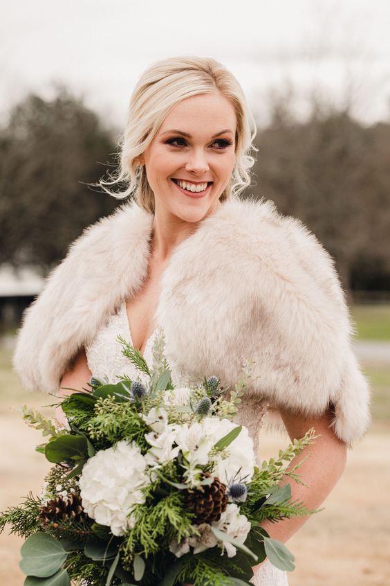 a simple and lovely winter wedding bouquet of white blooms, greenery, evergreens, thistles, pinecones is a beautiful and textural solution for winter