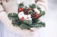a simple rustic wedding bouquet with evergreens, cotton, pinecones and holly berries can be easily DIYed by you