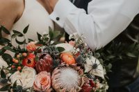 a subtle summer or fall wedding bouquet or orange, pink and neutral blooms, thistles, foliage and berries is a pretty idea for the fall