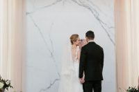 a timeless marble wedding backdrop with some greenery and blooms around is a gorgeous idea for a minimalist wedding