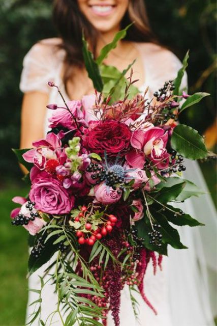 a vibrant fall wedding bouquet of pink and fuchsia blooms, various berries, foliage and twigs is a gorgeous solution for a fall bride
