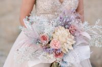 an iridescent wedding bouquet with fresh and dried blooms and fronds plus blue ribbons is a very cool and chic idea to rock