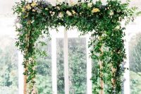 a beautiful greenery wedding arbor decorated with just a bit of pastel blooms is a stylish idea for a spring or summer wedding