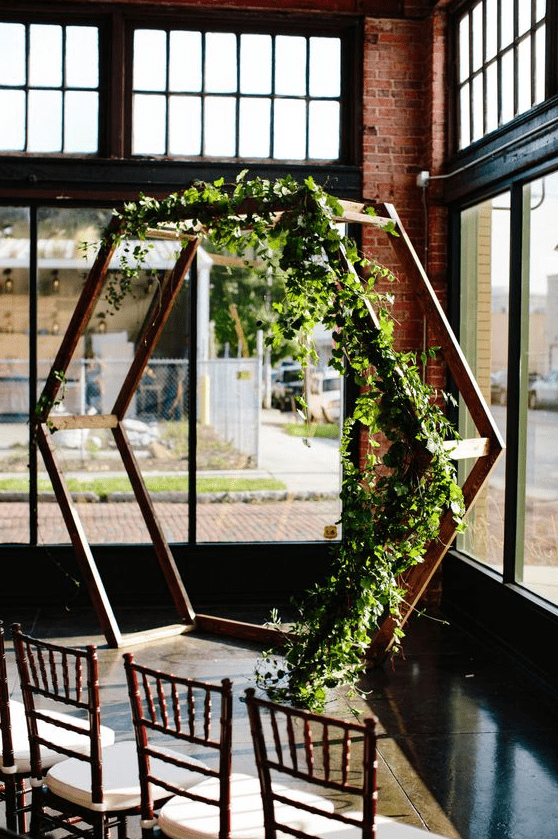 a lovely spring hex wedding arch decorated with greenery is a simple and very cool idea that feels and looks fresh