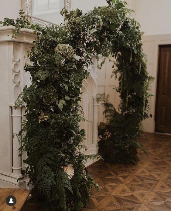 a lush textural greenery wedding arch with neutral blooms is a very spectacular decoration