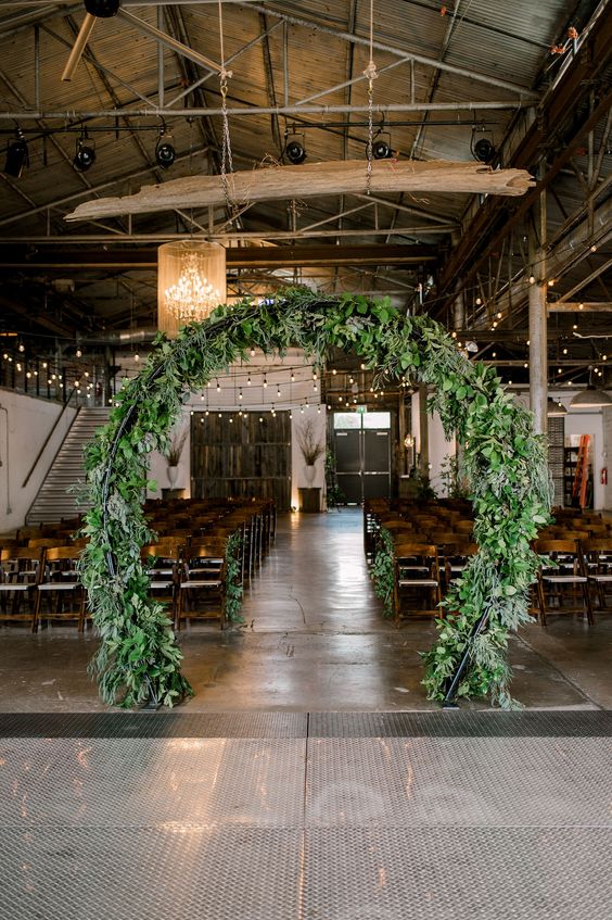 a round greenery wedding arch is a great idea for an indoor wedding, it will bring an outdoor feel to the space