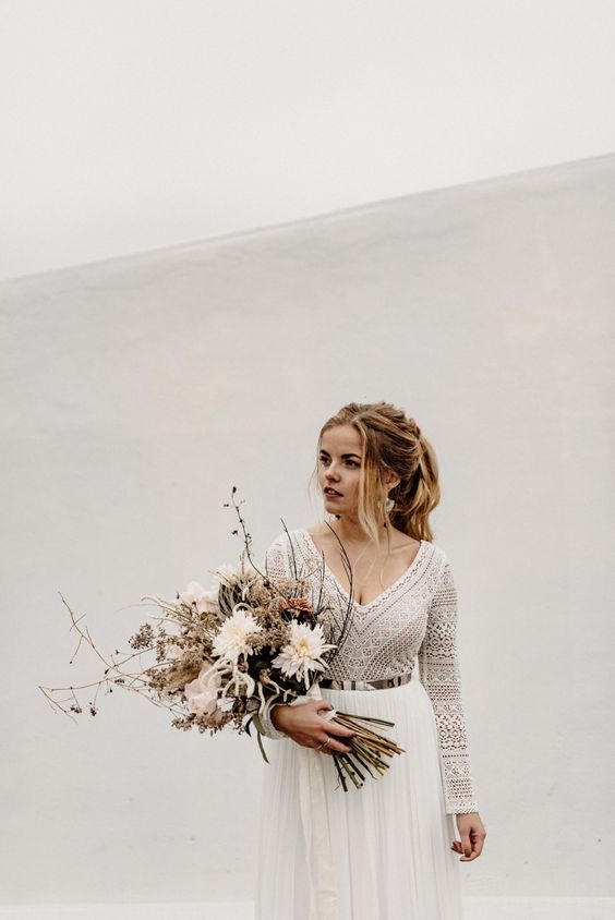 a chic modern winter bridal look with a boho lace top and a pleated maxi skirt plus a metallic belt and a lovely textural wedding bouquet