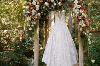 05 a dreamy and bold Christmas wedding arch with lush white, burgundy roses and greenery is a luxurious idea