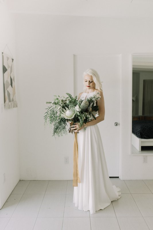 a modern winter bridal look with a plain A-line wedding dress with no sleeves, a cut on the front and a maxi skirt is wow