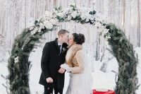 15 a round wedding arch of evergreens and with lots of white blooms on top is a fantastic idea for a snowy Christmas wedding