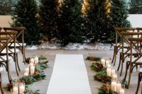 27 a row of Christmas trees with no decor at all for a natural feel, greenery and magnolia leaves plus candles to line up the aisle